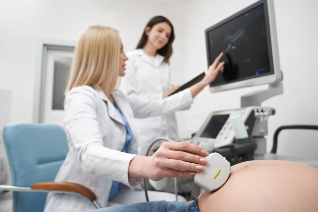 Doctor doing ultrasound examination of pregnant woman