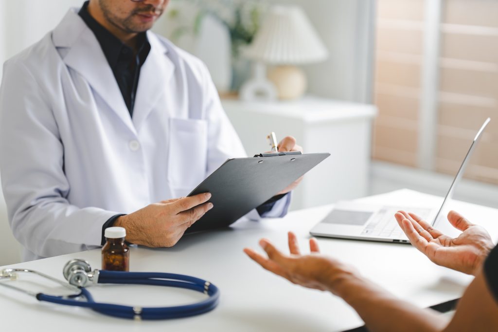 Doctor talking to patient and filling patient history, examination, treatment, medical and health co